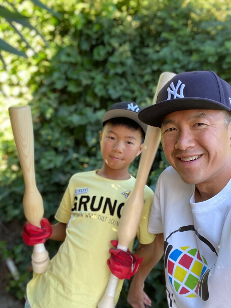 Simon and his oldest son at age 10 holding two Camwood training bats.
