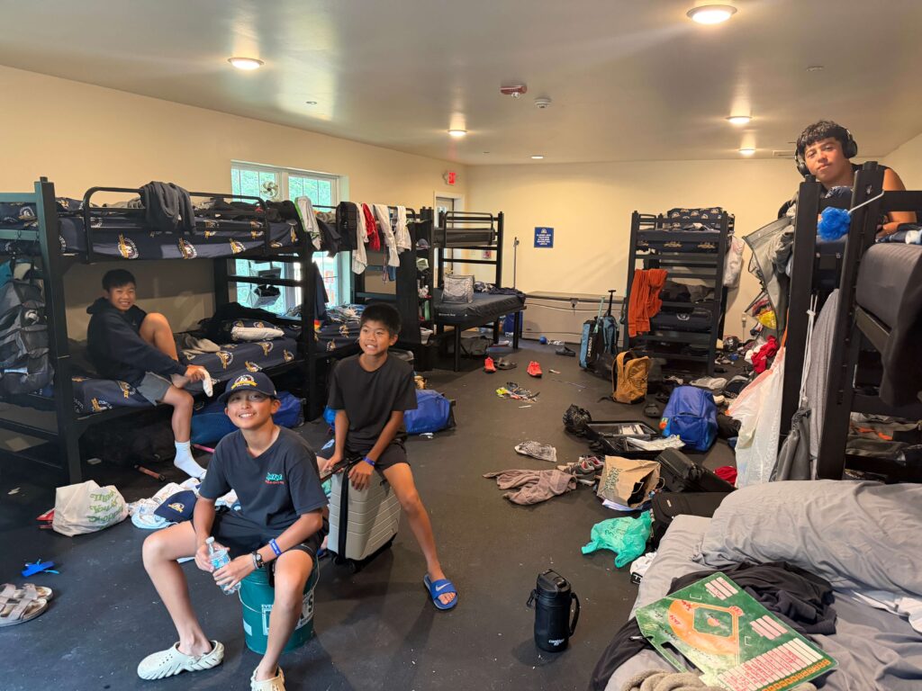 Kids smiling and watching TV inside a messy bunk