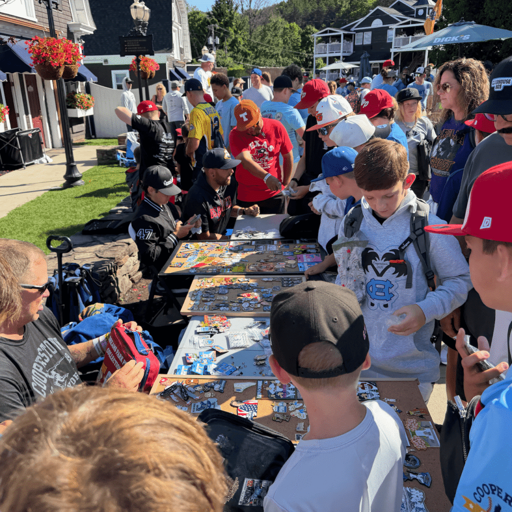 kids around a table at Cooperstown baseball tournament and pin trading with each other