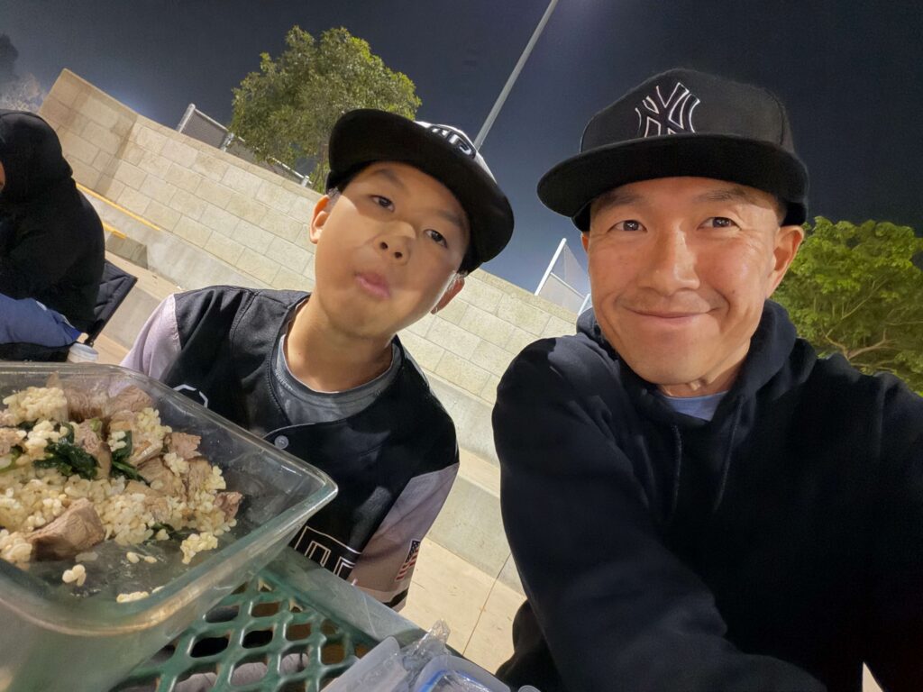 Simon and his son eating a good meal during game break at a baseball tournament