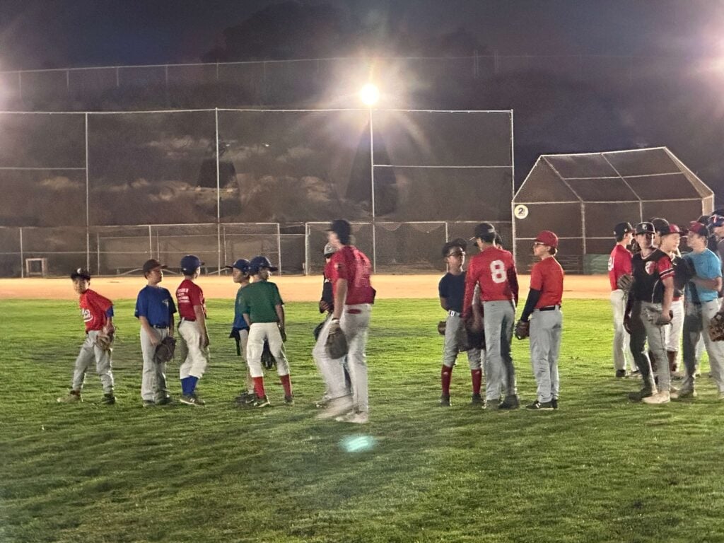 Kids dressed in different uniforms from different age groups, getting ready for a club baseball tryout